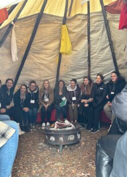 Group of women in jackets sitting in a tipi