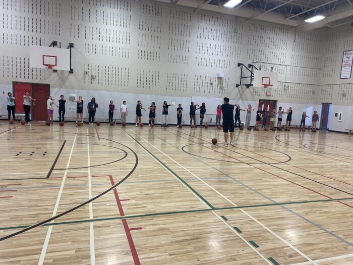 Girls lined up in a gym ready to play basketball