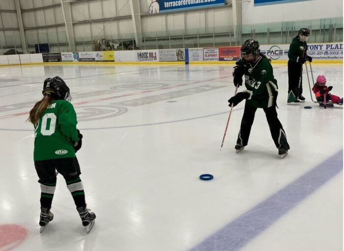 Two girls practicing passing in ringette.