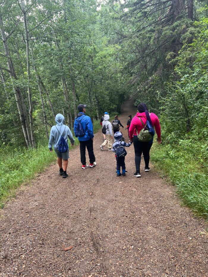 Group of people walking on a gravel path in a ravine.